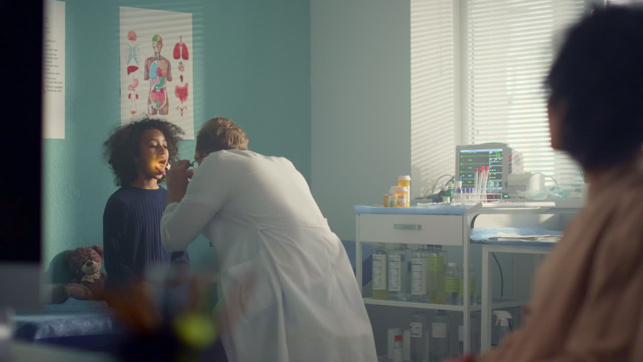 el médico examina la garganta de la niña en el hospital. la madre lleva al niño adolescente al pediatra.