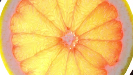 vista superior girar una rebanada de naranja sobre un fondo blanco, una rebaja transparente de pomelo fresco sobre un fondo branco, resolución 4k