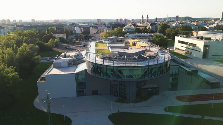 Vista aérea de um campus moderno com uma pista de corrida na cobertura de um edifício moderno.