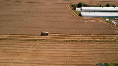 Cosechadora-Trabajando-En-Un-Campo,-Vista-Aérea-Desde-La-Distancia