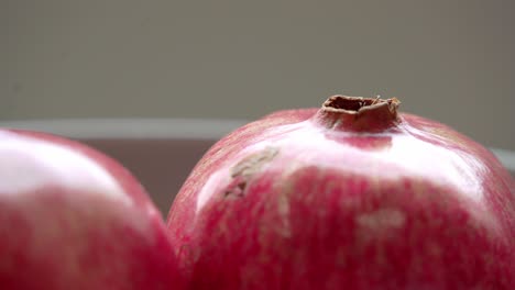 pomegranate sitting on white plate on table ready to be cut open healthy anti-oxidants cardioprotective properties