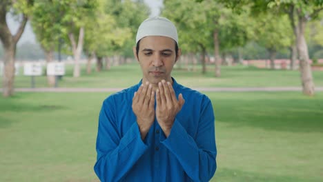 religious muslim man reading namaz in park