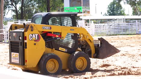 construction vehicle moving dirt in an arena