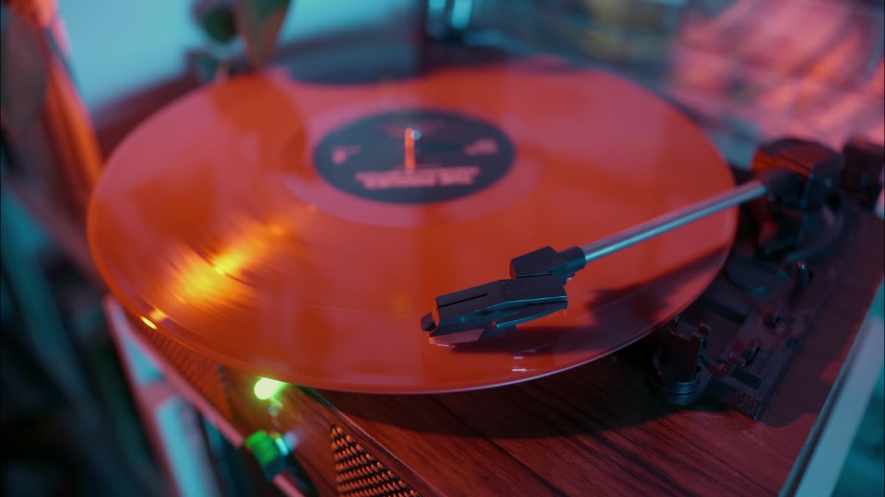 Mano che posiziona la puntina su un disco in vinile rosso su un giradischi
