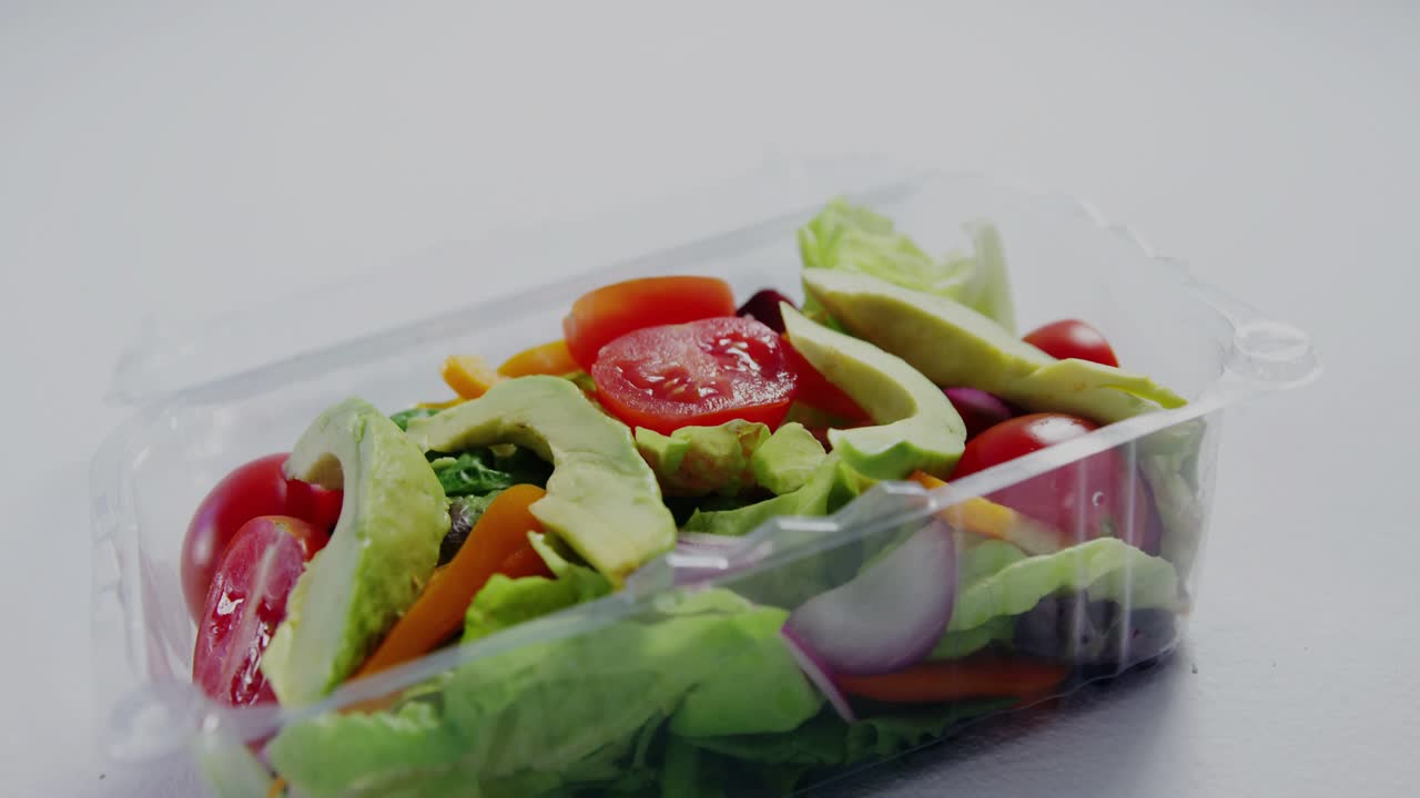 HUD graphics fading in, overlaying clamshell salad while camera pushing, gathering nutrition data