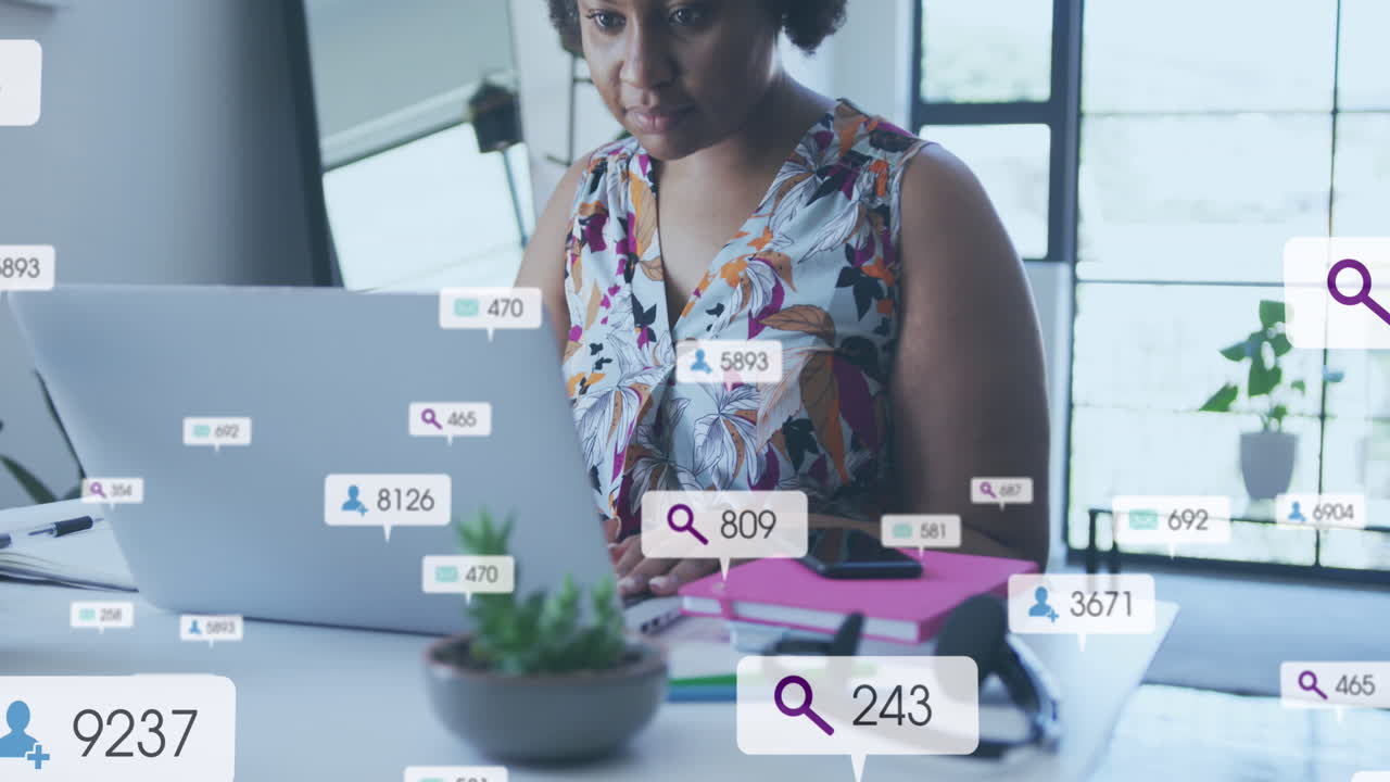 Animation of social media icons with numbers over african american woman using laptop