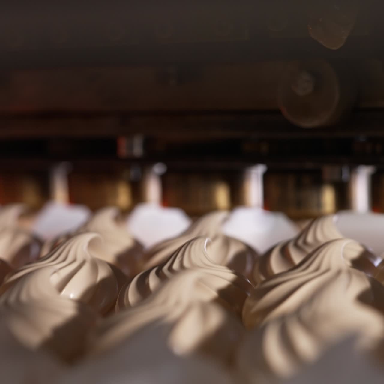 Automated line with rotating nozzles producing vanilla marshmallows. Close up. Food factory concept