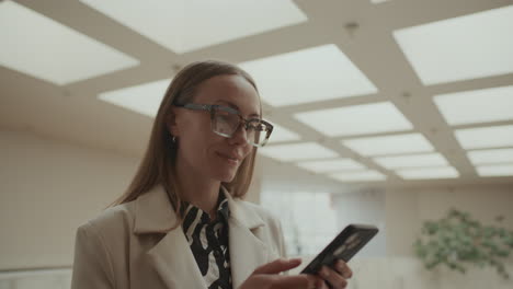 businesswoman scrolling on smartphone during break in office