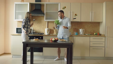 una pareja bailando en la cocina.