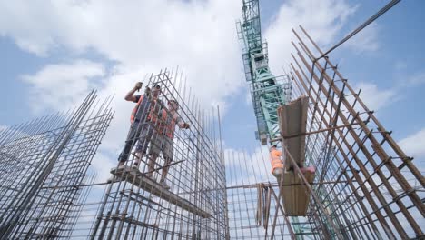 a worker uses steel tying wire to fasten steel rods to reinforcement bars. reinforced concrete structures - knitting of a metal reinforcing cage.