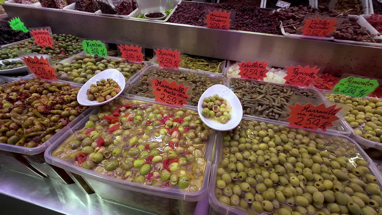un puesto de comida con todo tipo de aceitunas en un mercado en málaga, españa