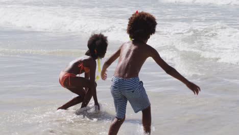 african american children wearing scuba goggles playing at the beach