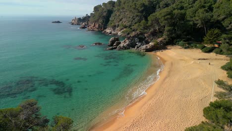 Genießen-Sie-Die-Faszinierende-Luftaufnahme-Der-Küste-Von-Lloret-De-Mar,-Wo-Kristallklares-Blaues-Wasser-Auf-Sandstrände-Trifft-Und-Luxusreisende-Nach-Santa-Cristina-Und-Cala-Treumal-Einlädt