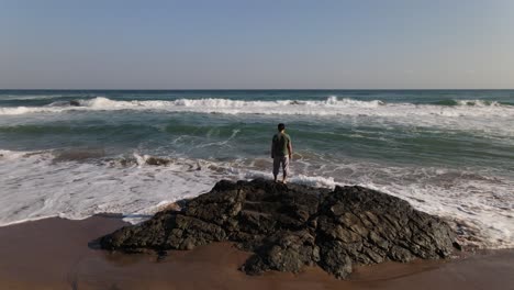 watching ocean waves on rock aerial view