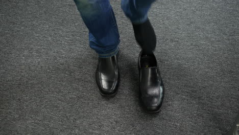 un hombre poniéndose los zapatos en la alfombra