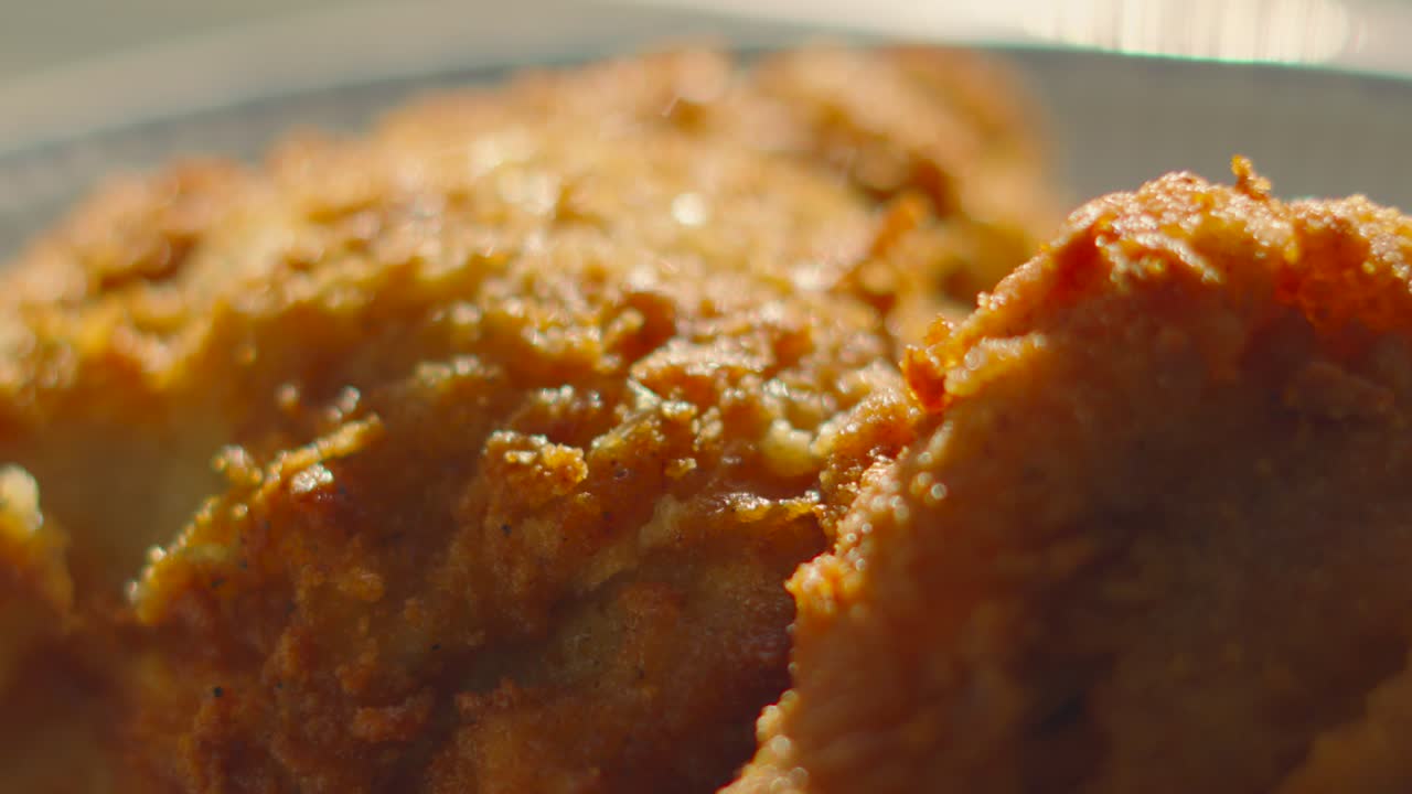 Close Up Details of Delicious Freshly Fried Chicken with Crispy Skin in Natural Sunlight. Ideal for Family Sharing Lunch or Dinner. Unhealthy Fat Fast Food Cooked in Deep Friars.
