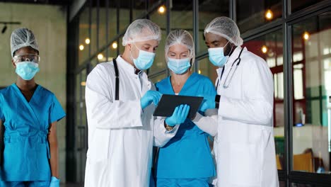 multi-ethnic male and femal doctors wearing medical masks and gloves