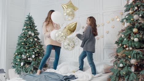 Glückliche-Damen,-Die-Mit-Sternballons-Auf-Dem-Bett-In-Einem-Privathaus-Spielen.