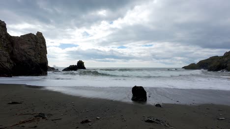 Moody-Sky-incoming-waves-at-secluded-beach-at-Bunmahon-Copper-Coast-Waterford-Ireland-at-dawn-on-a-spring-Morning