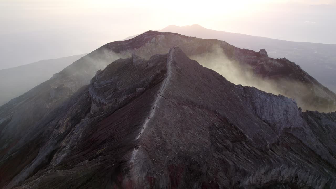 Pemandangan udara penentu dari ketinggian kawah Gunung Agung dan punggung bukit vulkanik yang terjal.