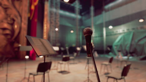 escenario vacío con micrófono, sillas y puestos de música