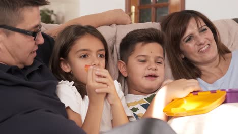 non-normative family watching the tv while eating candies together at home