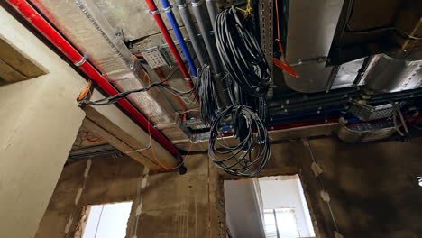 bundles of electric wires hanging at the new pipes on the ceiling. new electricity on the old building.