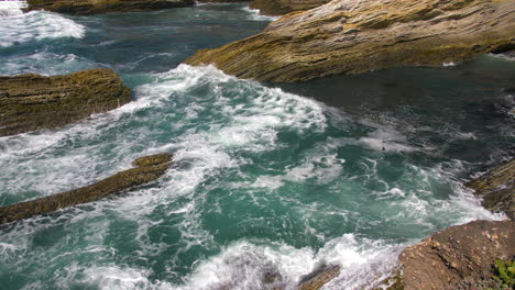 sea wave rolling through ocean rocks crashing on shore