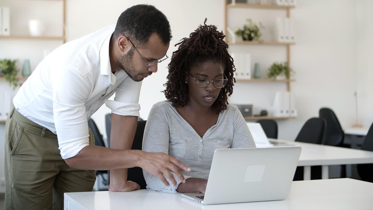 Front view of concentrated employees working with laptop