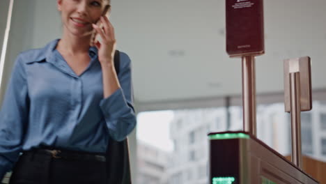 hermosa empleada desbloqueando la puerta electrónica oficina moderna hablando por teléfono celular.