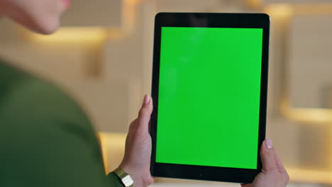 girl surfing internet chroma key tablet in workplace close up. unknown woman
