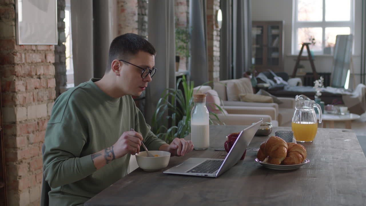 Freelance con laptop che fa colazione