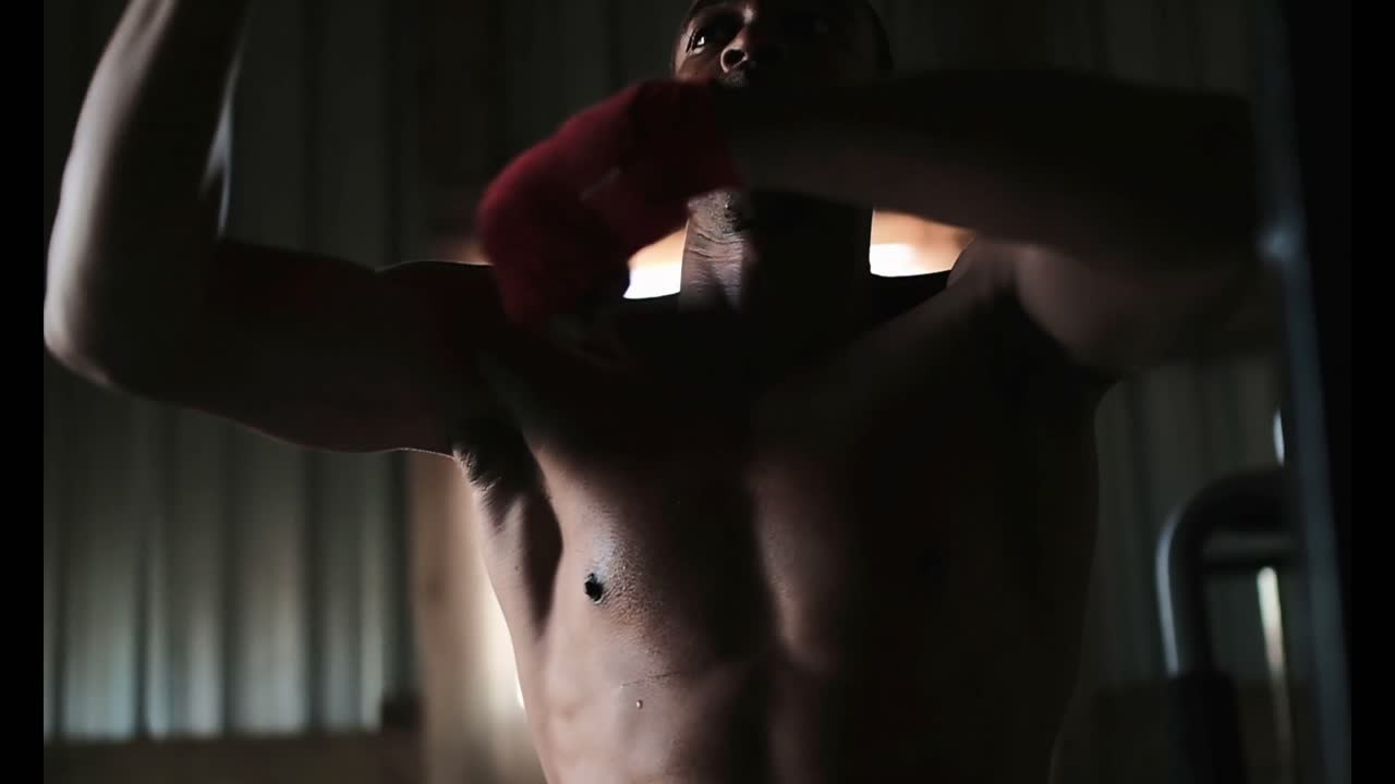 아프리카계 미국인 남성 권투 선수가 피트니스 스튜디오 4k에서 권투를 연습하고 있습니다.