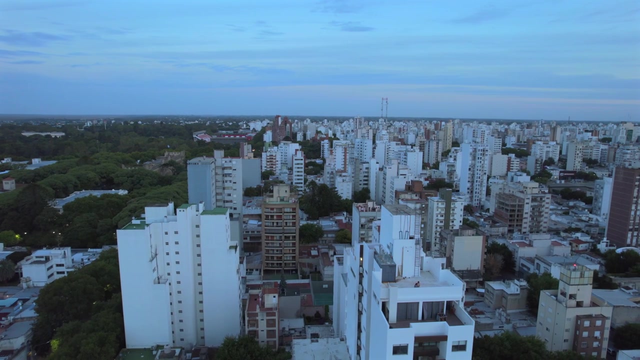Vista aérea de drone em 4K de La Plata, Buenos Aires, Argentina ao pôr do sol. Horizonte urbano, edifícios e ruas iluminados pela luz quente do entardecer por toda a cidade.