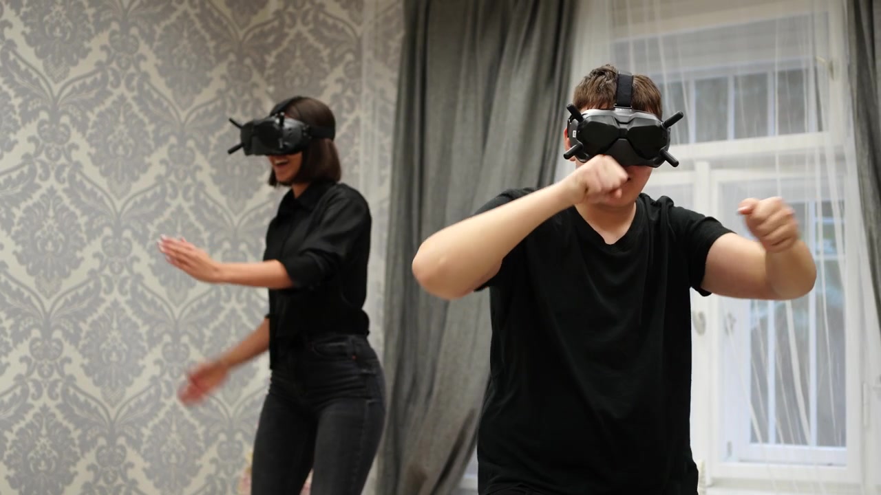 Coppia Felice Gioca a un Videogioco d'Azione in Realtà Virtuale Usando Visori VR