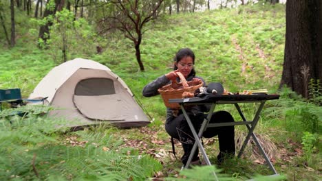 Mujer-Poniendo-Setas-Sobre-La-Mesa-En-El-Bosque-Con-Tienda