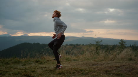 Man-doing-high-knee-taps-during-fitness-workout.-Guy-training-in-mountains