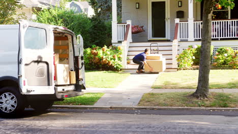 courier using trolley to deliver package to house