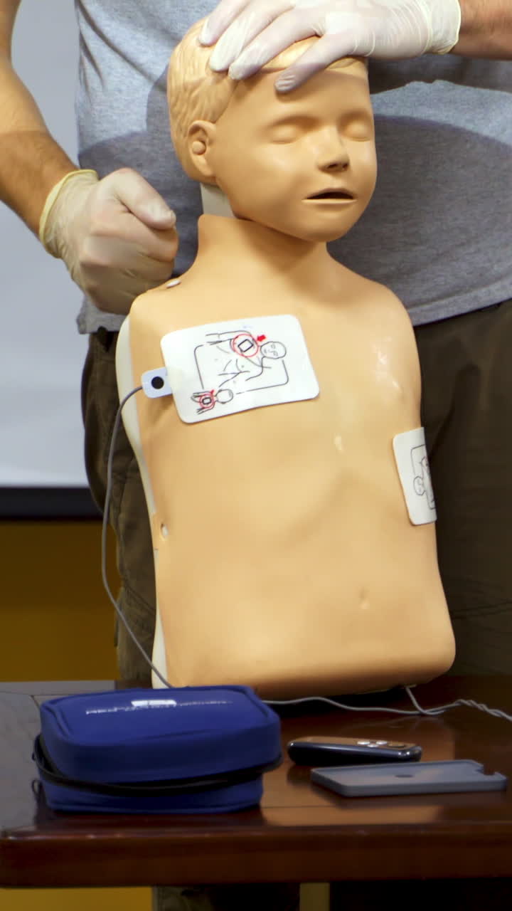 Medical training on a manikin. Instructor demonstrating the procedure of first aid on a dummy. Cardiopulmonary resuscitation. Vertical video