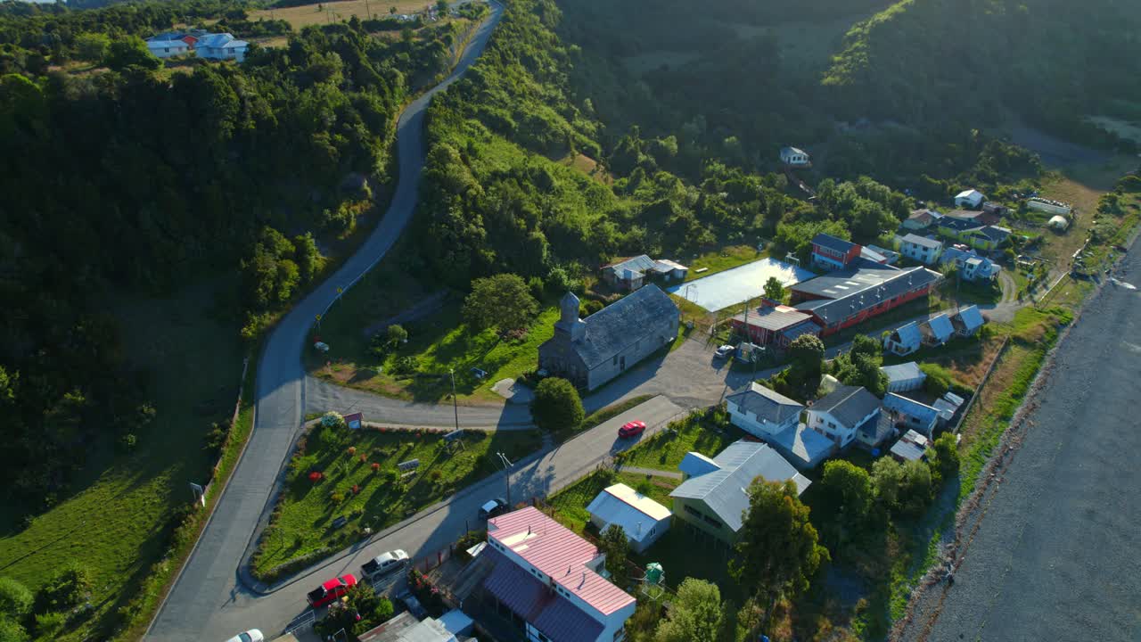 un avión no tripulado vuela por encima de la iglesia patrimonial de la unesco, detif chiloé paisaje de la patagonia chilena del horizonte, montañas de la isla verde, casas y viajes por carretera de américa del sur