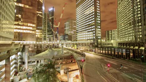 Un-Cautivador-Timelapse-Revela-Un-Intrincado-Paisaje-Urbano-Nocturno,-Repleto-De-Altos-Edificios-De-Diversos-Diseños,-Junto-A-Una-Bulliciosa-Carretera-Arqueada-Sobre-Un-Sitio-De-Construcción-Activo.