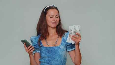 happy young woman use smartphone rejoicing win, receiving money cash , success lottery jackpot luck