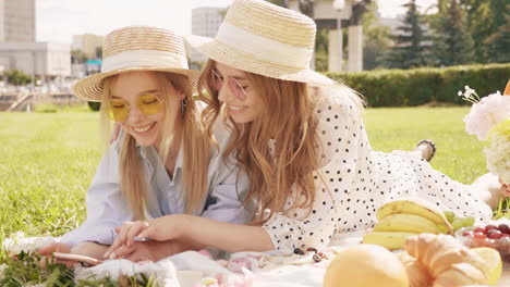 two girls enjoying a picnic in the park