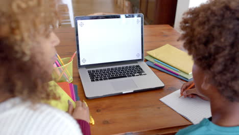 African-american-mother-and-son-using-laptop-with-copy-space-on-screen,-slow-motion