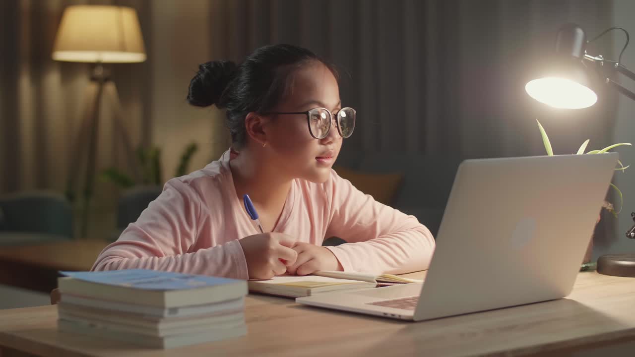 Teenage Girl Learning Online From Laptop At Night