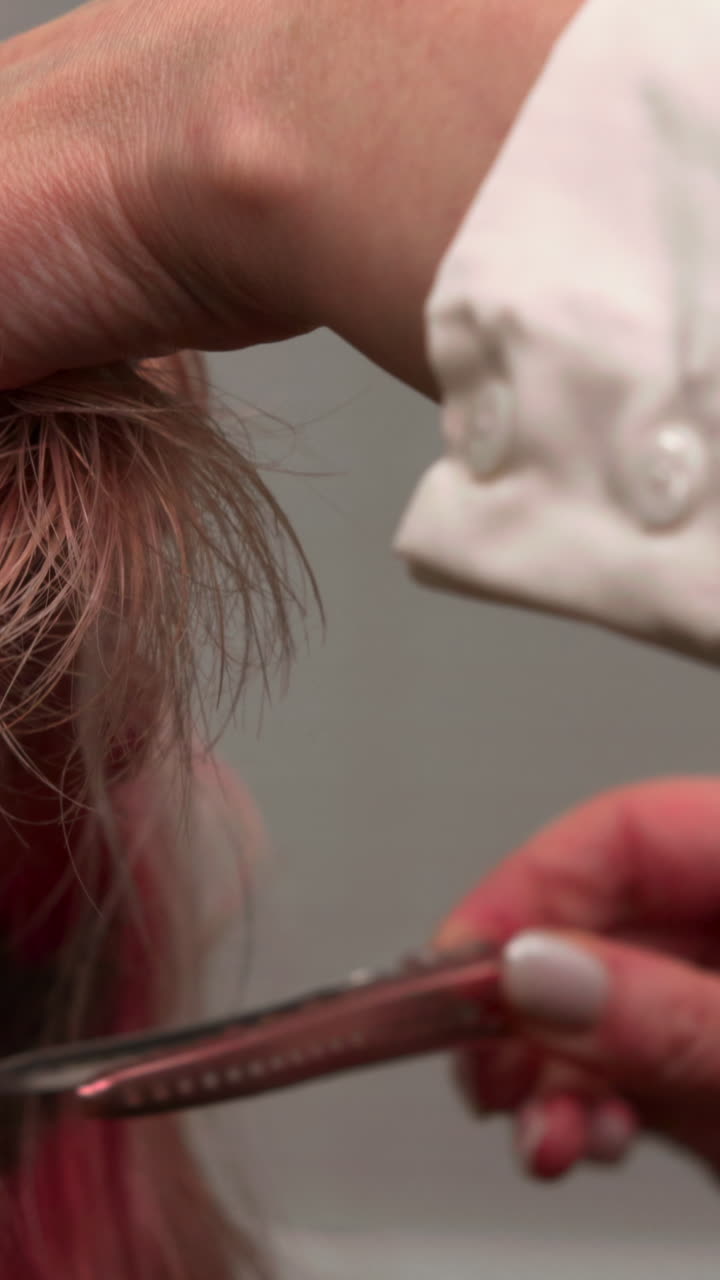 Close-up of Hairdresser Sectioning Pink and Blonde Hair with a Clip