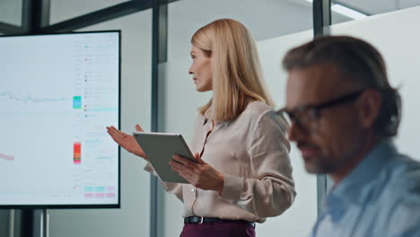 Inspired-woman-pointing-screen-in-office-close-up.-Female-speaker-mentoring-team