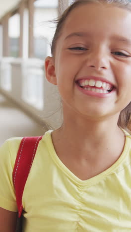 video de una chica caucásica feliz de pie en el pasillo de la escuela