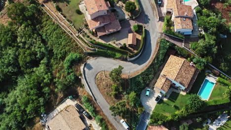 Tanneron-Francia-Antena-V13-Toma-De-Establecimiento,-Vista-Vertical-Hacia-Abajo-Que-Captura-El-Camino-Sinuoso-De-La-Colina-Y-Las-Casas-Residenciales-Locales-En-Les-Mauberts---Julio-De-2021