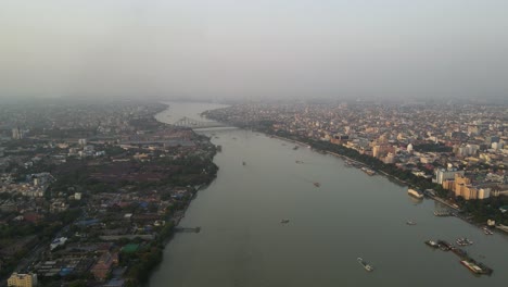 aerial drone shot of howrah bridge spanning the hooghly river, a landmark of kolkata's rich heritage.